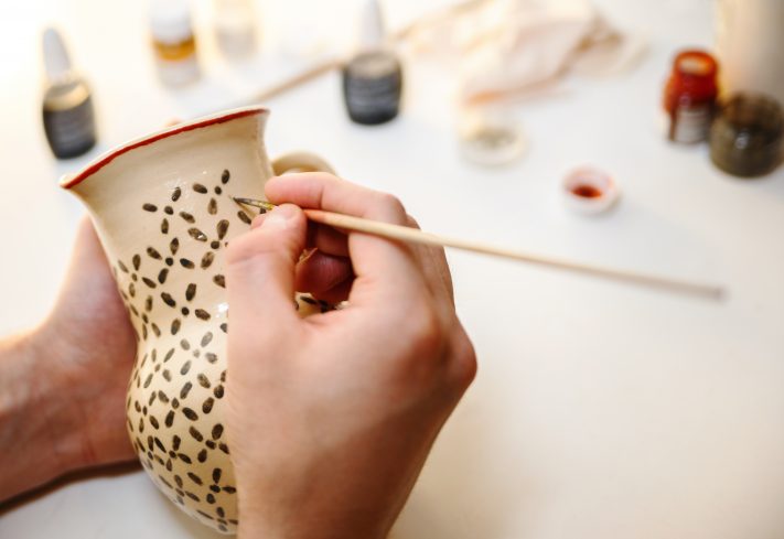 Person painting pottery